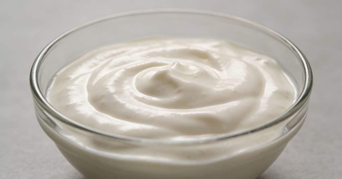 Bol en verre rempli de sauce cremeuse blanche