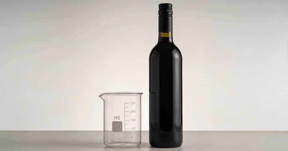 Bouteille de vin debout proche verre dose marque ml