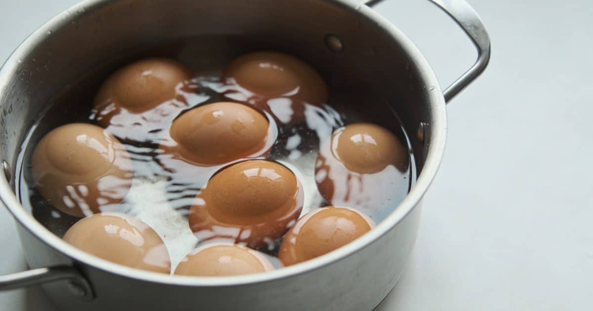 Casserole en metal avec oeufs immerges dans eau