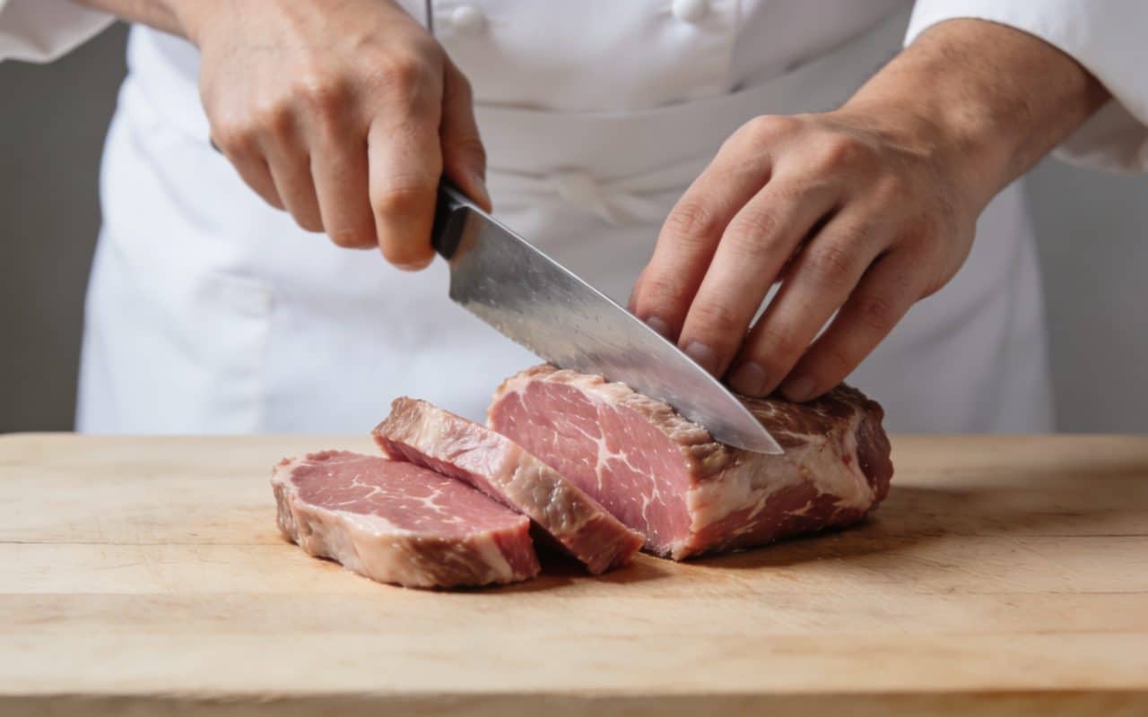 Chef tranchant un filet mignon de porc
