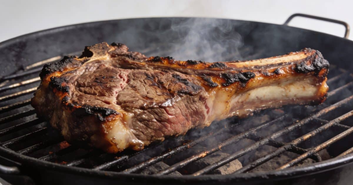grosse cote de boeuf grillee sur barbecue fumant