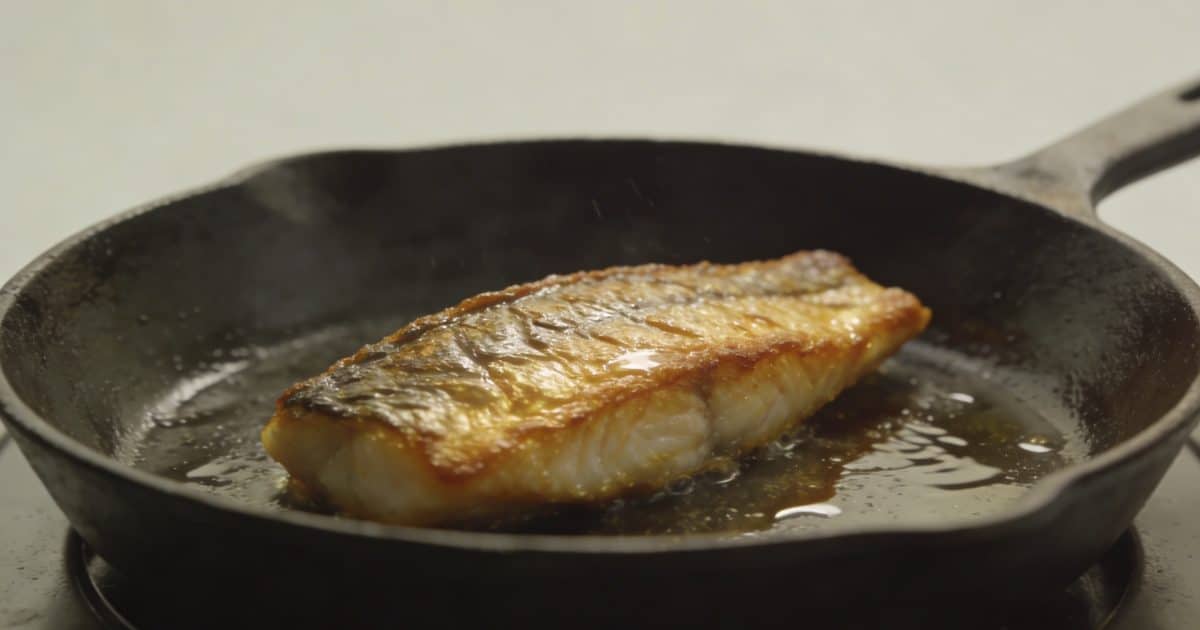 Filet de poisson dore dans poele en fonte