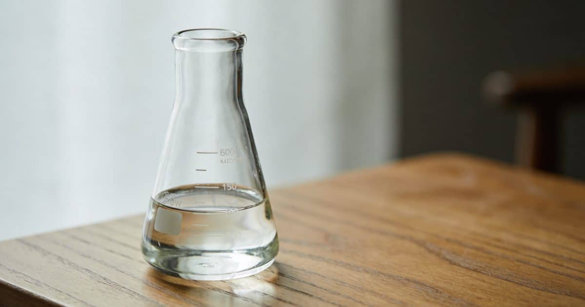 Verre doseur sur table en bois, liquide clair