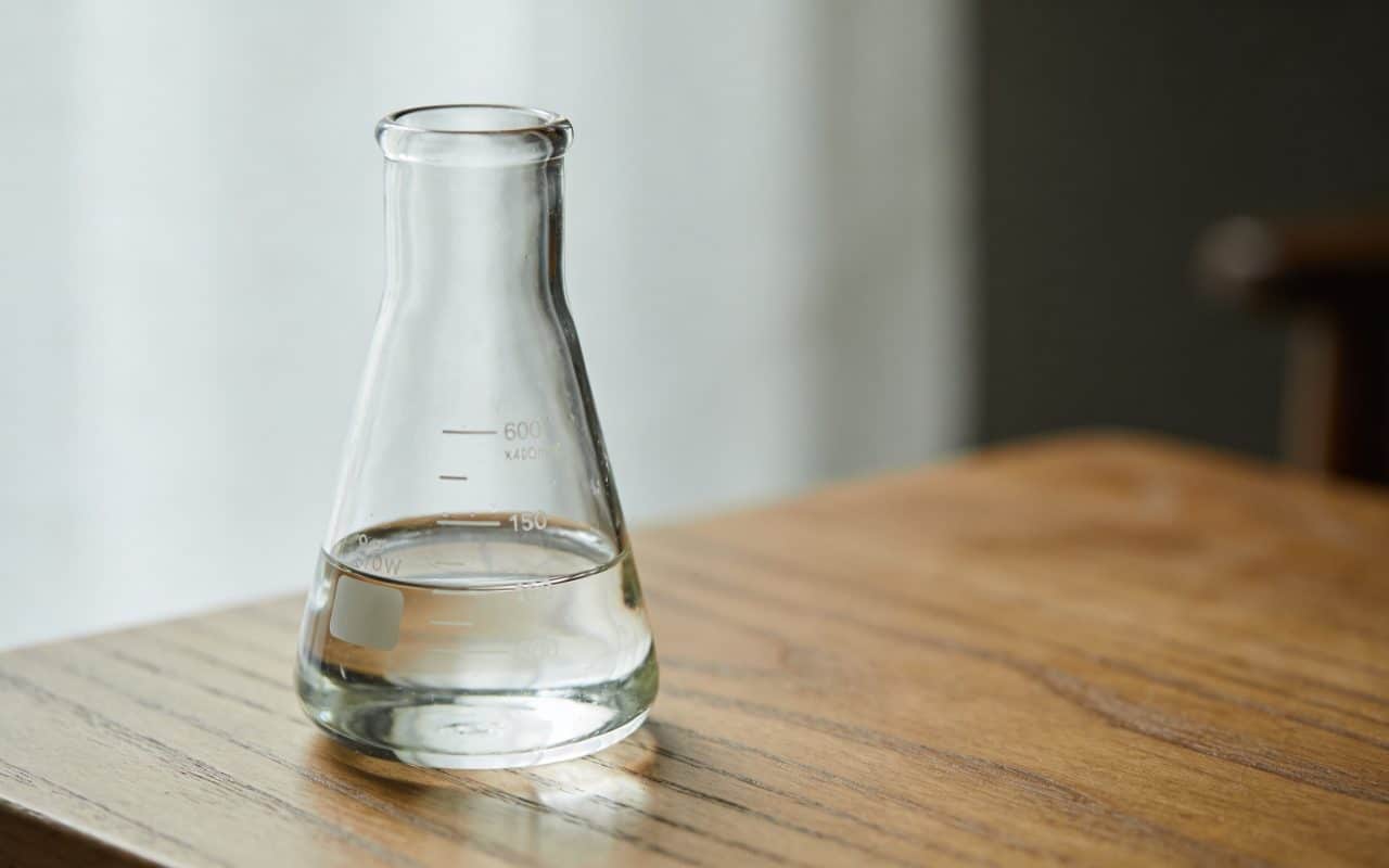 Verre doseur sur table en bois, liquide clair