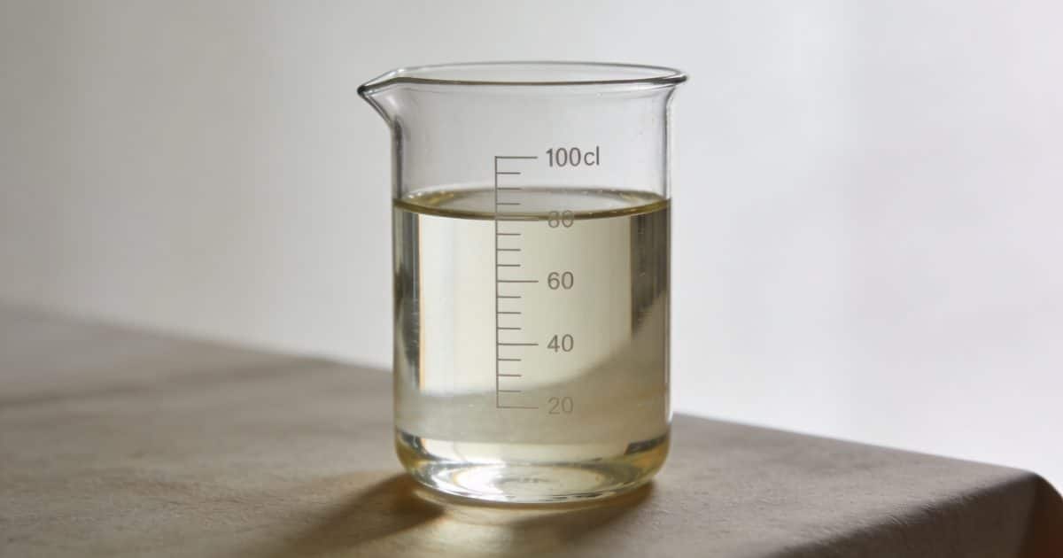Verre doseur transparent rempli a 100 cl sur table