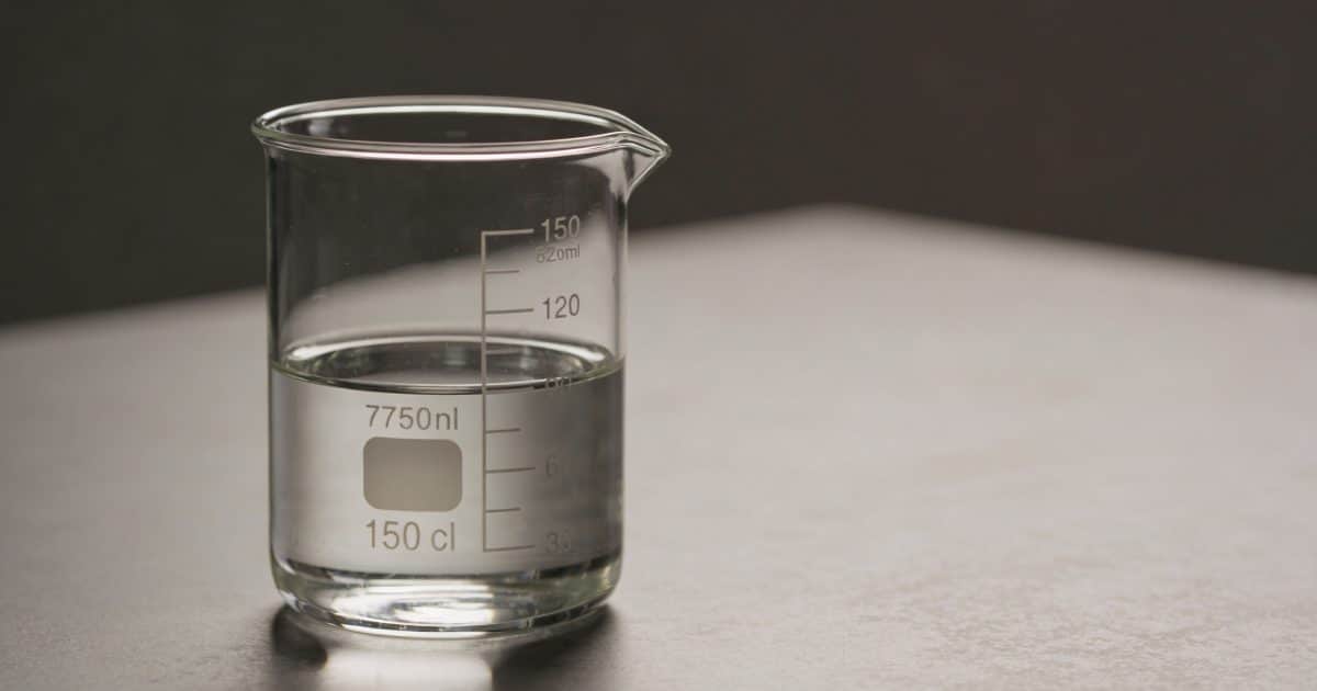Verre doseur transparent rempli a 150 cl sur table