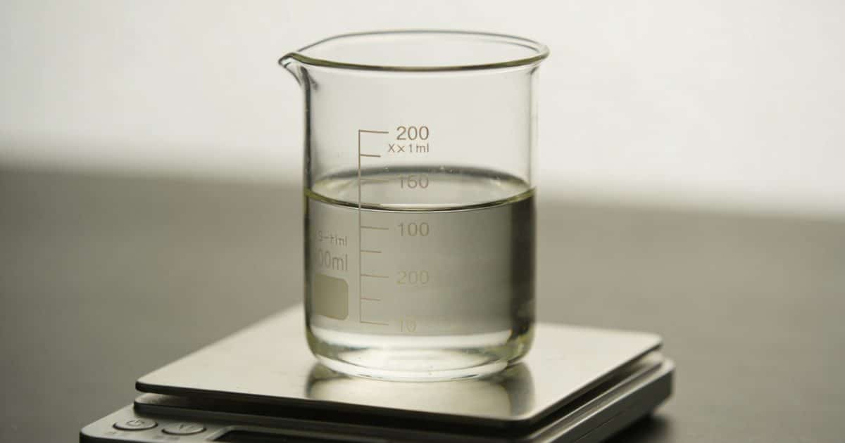 Verre doseur transparent rempli de liquide sur balance