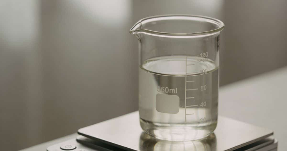 Verre doseur transparent rempli de liquide sur balance