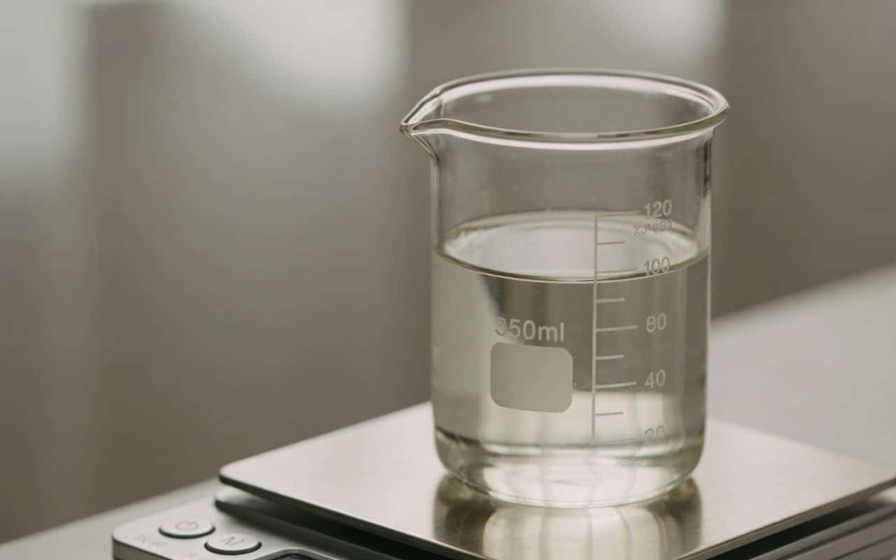 Verre doseur transparent rempli de liquide sur balance