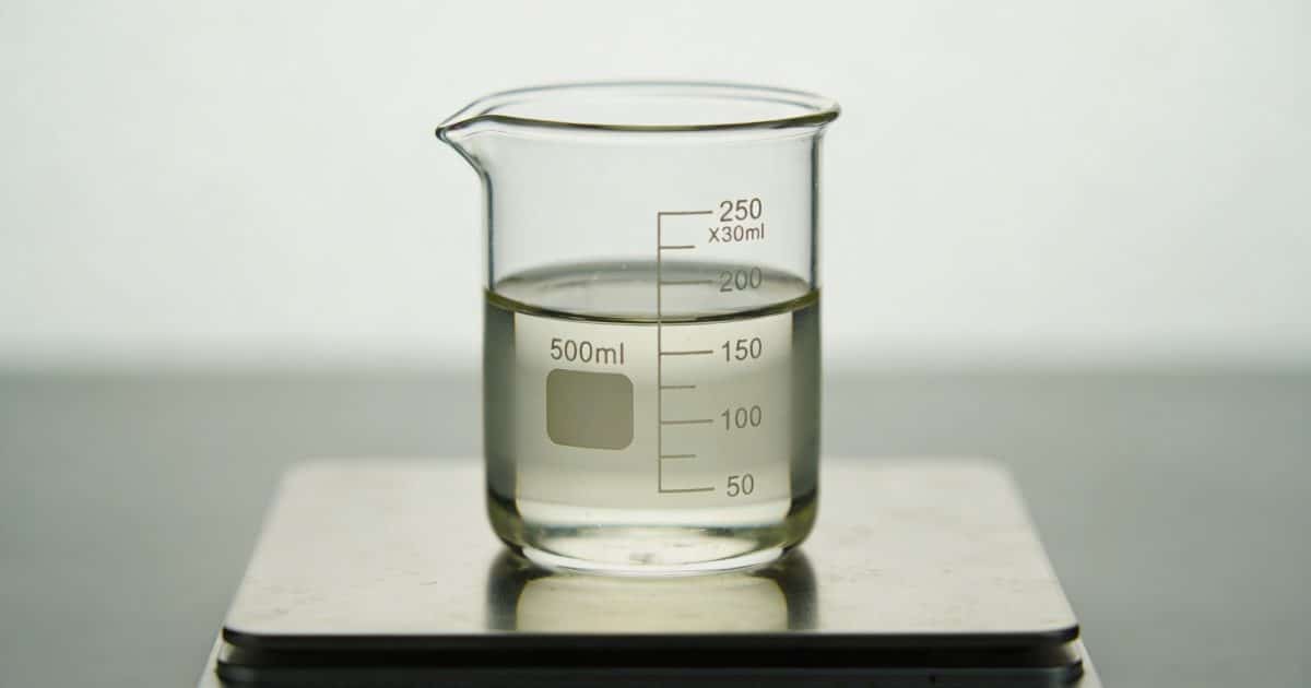 Verre doseur transparent rempli de liquide sur balance