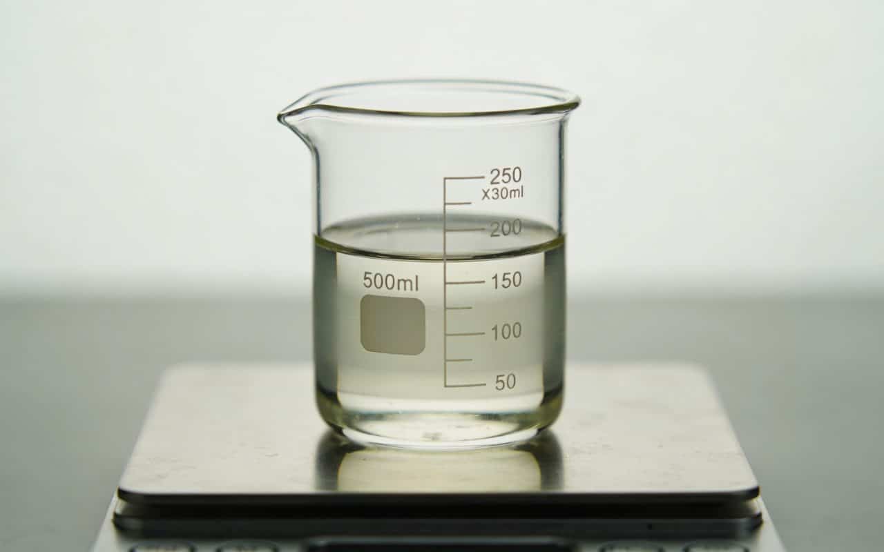 Verre doseur transparent rempli de liquide sur balance