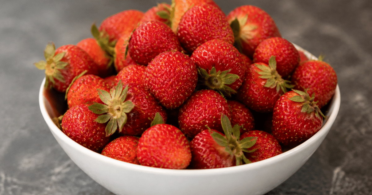Fraises rouges entassees dans un bol blanc pose