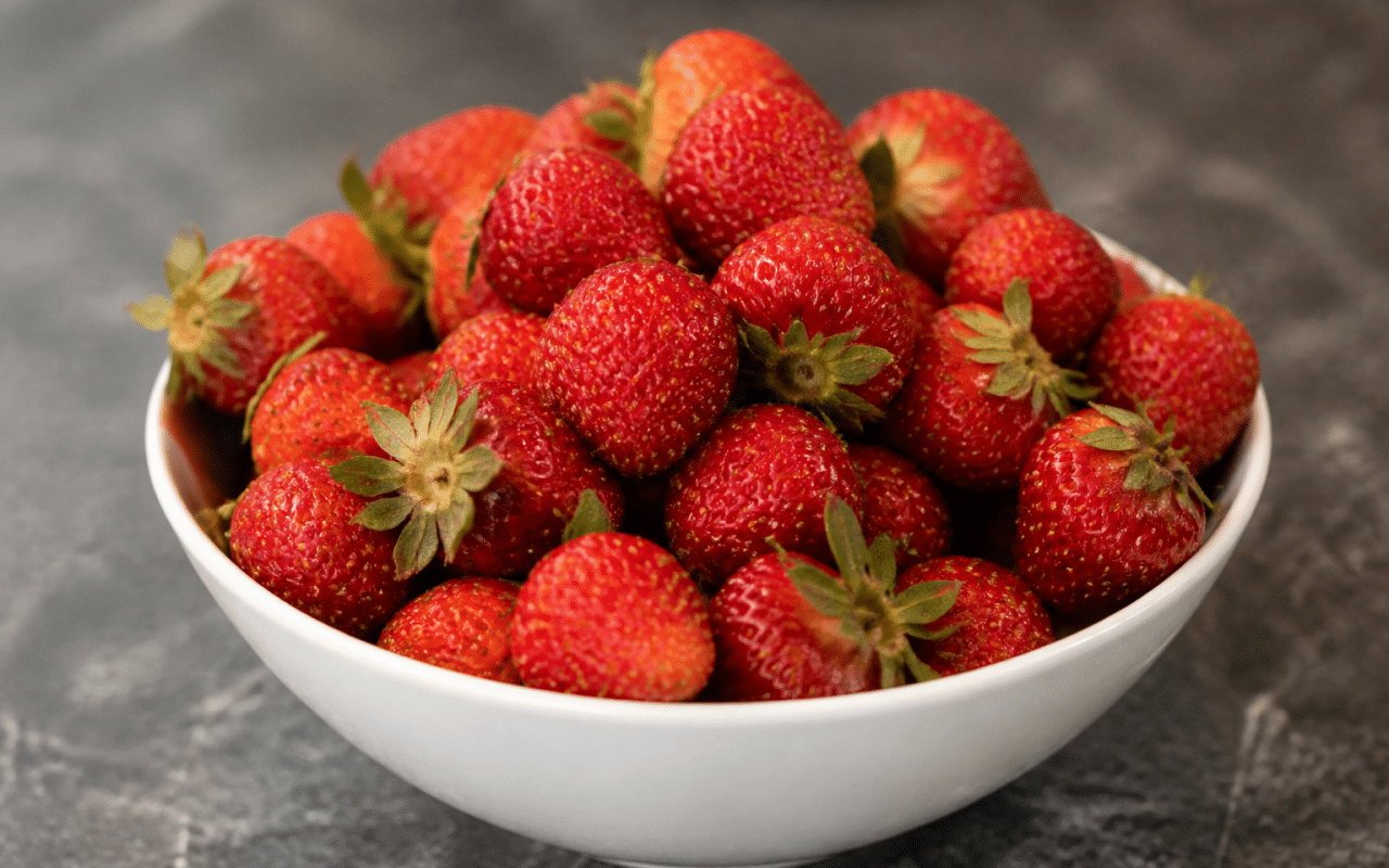 Fraises rouges entassees dans un bol blanc pose