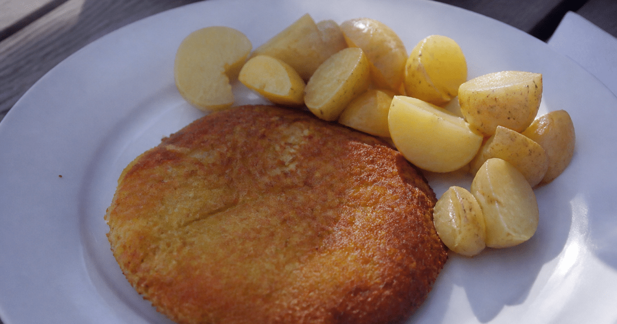 galette dorée posée sur assiette blanche avec pommes de terre