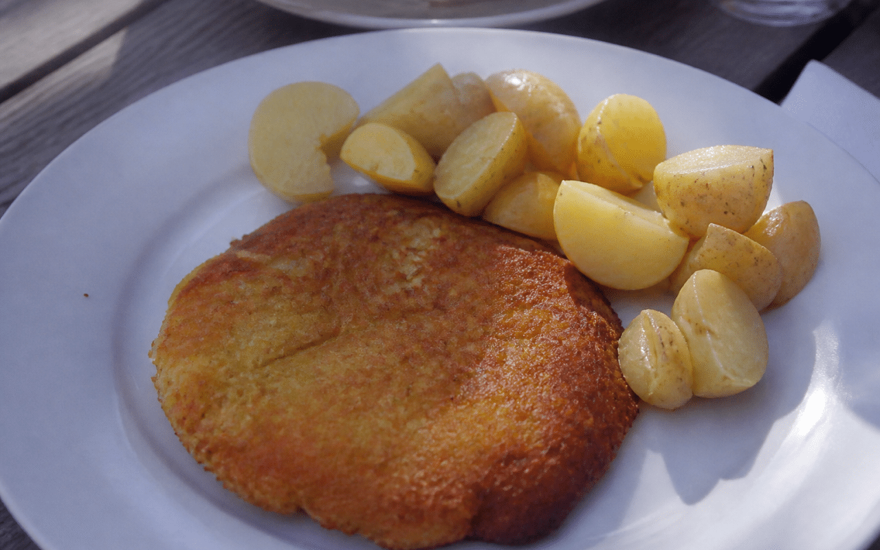 galette dorée posée sur assiette blanche avec pommes de terre