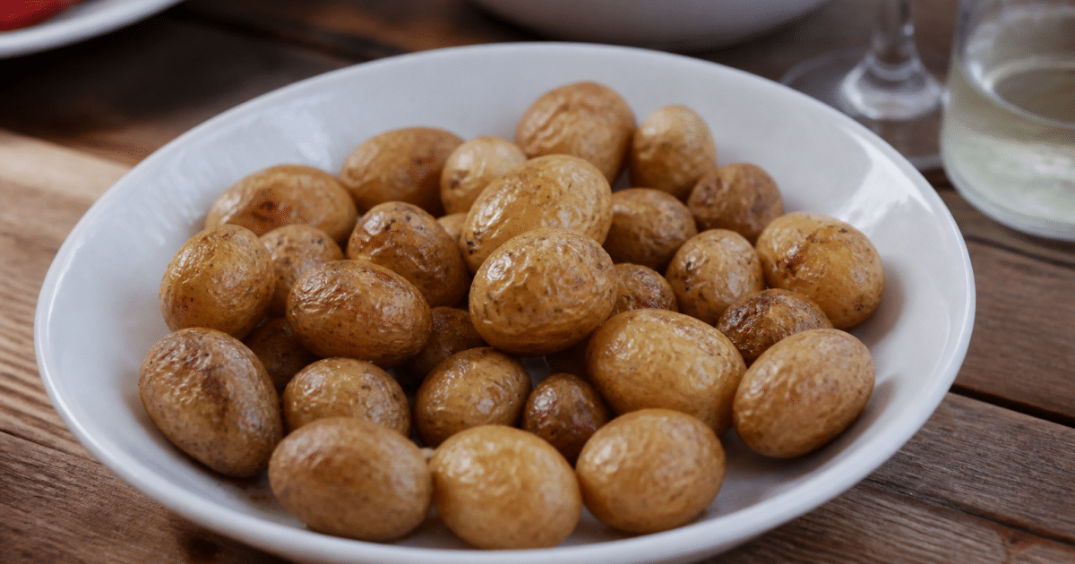 Petites pommes de terre grenaille cuites dans assiette blanche
