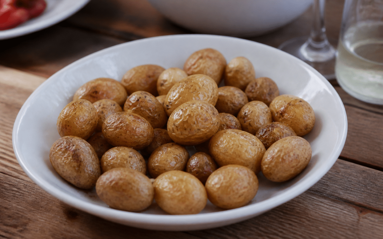 Petites pommes de terre grenaille cuites dans assiette blanche