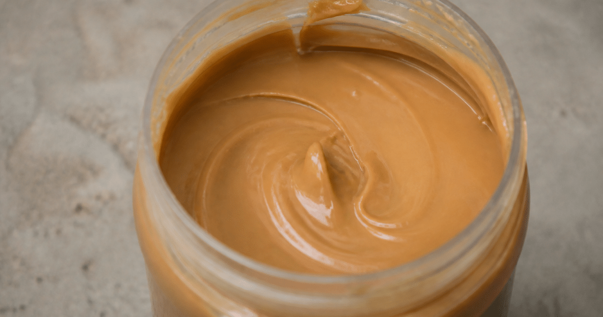 Pot ouvert rempli de pate lisse couleur caramel
