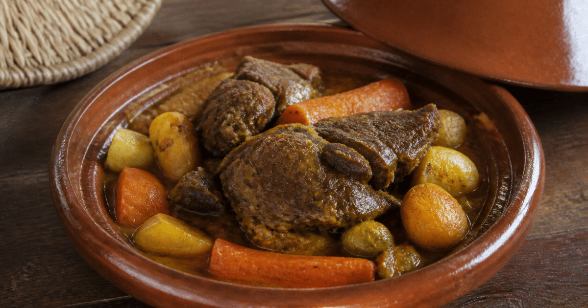 Tajine marocain en céramique contenant agneau braisé aux légumes