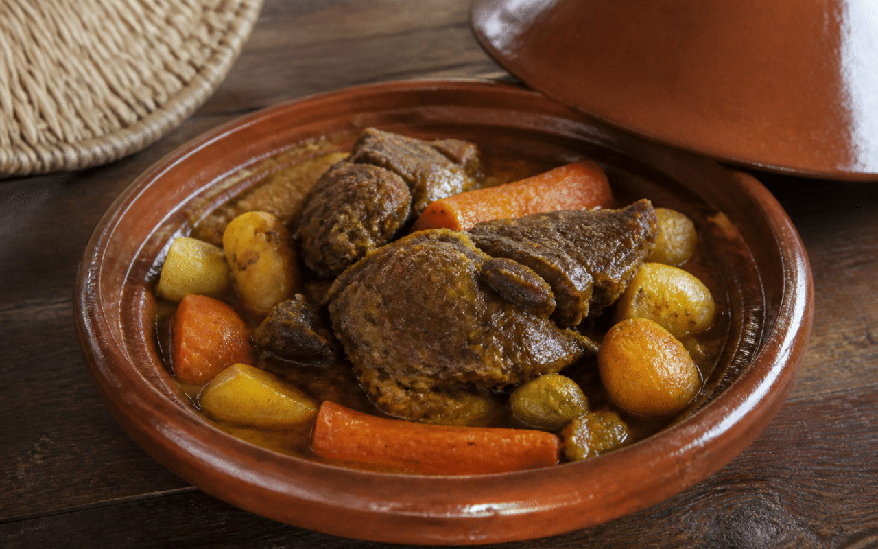 Tajine marocain en céramique contenant agneau braisé aux légumes